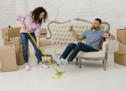 woman-mopping-floor-near-resting-man